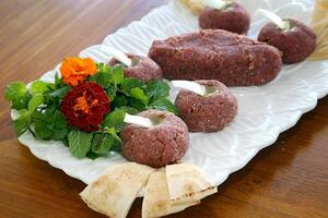 crudo kibbeh con cebolla y aceituna petróleo en bandeja foto