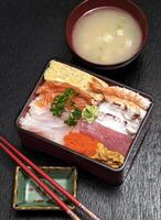 Tirashi, Japanese delicacy with salmon, squid, cucumber, nori, kani kama and salmon roe photo