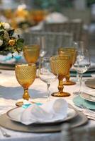 sophisticated lunch table setup in yacht club with plates, glasses, flowers and cutlery photo