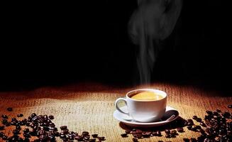 hot espresso coffee in white cup on jute background photo