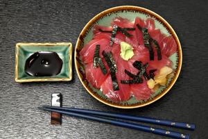 Tekka donburi, Japanese dish with rice topped with marinated tuna sashimi, soy sauce, mirim and chives photo