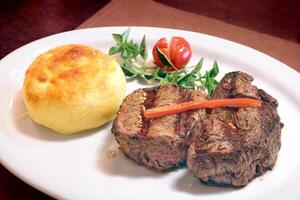 ancho steak with cheese bread with cream cheese on the plate photo