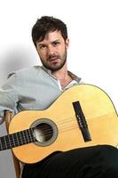 young model with mustache posing with his guitar on neutral background photo