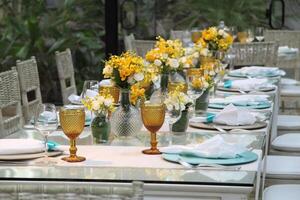 sophisticated lunch table setup in yacht club with plates, glasses, flowers and cutlery photo