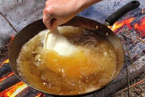 fogazza siendo frito en un pan con caliente petróleo foto