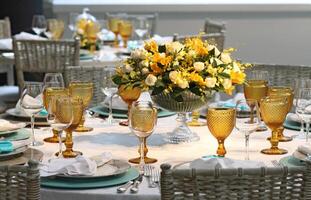 sophisticated lunch table setup in yacht club with plates, glasses, flowers and cutlery photo