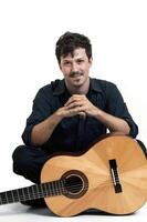 young model with mustache posing with his guitar on neutral background photo