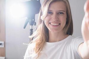 selfie of woman maker at work, using and controlling light strobe photo