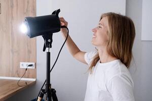 mujer fabricante a trabajar, trabajando en contenido haciendo, utilizando y controlador ligero luz estroboscópica foto