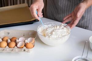 hombre vistiendo delantal Cocinando Tiramisu a cocina foto