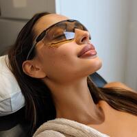Close up portrait of a young woman patient receiving a laser treatment in a spa salon. photo