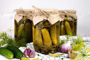 Canned cucumbers on a kitchen table. Delicious homemade pickles. Close-up. photo