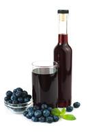 Fresh blueberry juice in a glass and ripe blueberries on a white background. Healthy, vitamin juices. Close-up. photo