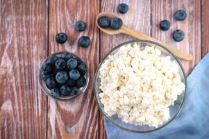 Homemade cottage cheese and fresh berries and on the wooden background. Healthy food concept. Close-up. Copy space. Selective focus. photo