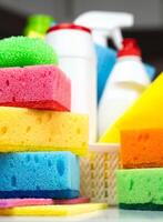 Various kitchen sponges, detergents and cleaning products on the kitchen table. Spring cleaning concept. Close-up. Selective focus. photo