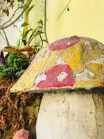 a colorful mushroom is sitting on top of a wall photo