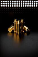 Pistol cartridges 9 mm on a smooth glossy surface with reflections. Ammunition for pistols and PCC carbines on a dark back. photo