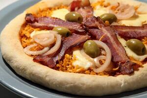 shredded chicken pizza with bacon slices, olives and cheese photo