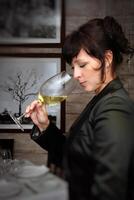 hermosa profesional sumiller saboreo y evaluando vinos en restaurante foto