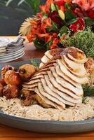 Sliced turkey with crumbs and fruits on tray photo