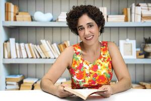 joven mujer leyendo y escritura a su escritorio foto