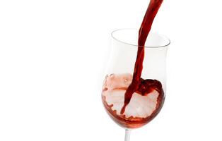 red wine being served in a glass on a white background photo