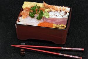 Tirashi, Japanese delicacy with salmon, squid, cucumber, nori, kani kama and salmon roe photo