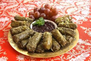 grape leaf cigars stuffed with meat accompanied by grape jelly photo