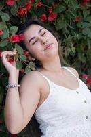 hermosa joven mujer vistiendo blanco verano vestir rodeado por buganvilla flores foto