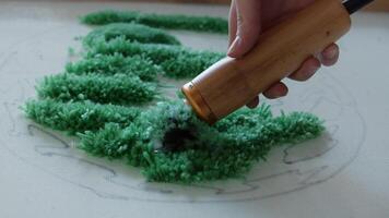 Creating a carpet with your own two hands. A woman carefully trims the carpet's pile with a trimmer. Close up. Slow motion. 4k. video