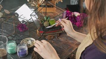 Kolla på en skicklig blomsterhandlare skapa skön Arbetar av konst använder sig av annorlunda typer av växter och former i en mästarklass. tack till henne kreativitet och skicklighet, unik blommig kompositioner är skapas. långsam rörelse. stänga upp. 4k. hög vinkel video