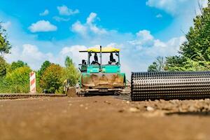 Road roller at a road construction site. New road construction. Suuny day. Ground road to be layed with asphalt. photo