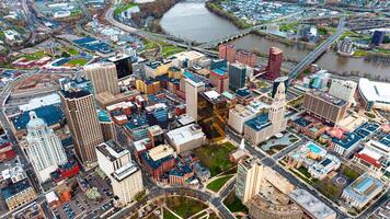 Downtown of beautiful modern Hartford, Connecticut, the USA at daytime. View on the river floating through the city at backdrop. Aerial perspective. photo
