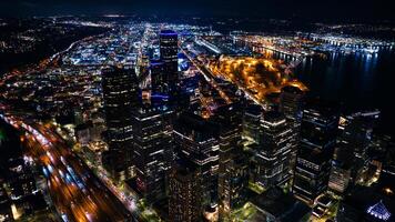 escénico ver de increíble Seattle a noche. animado panorama de el ciudad con maravilloso iluminación en el edificios y calles parte superior vista. foto