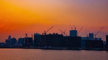 A time lapse of moving cranes at the bay area in Tokyo at dusk wide shot video