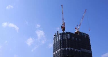 Moving cranes at the under construction behind the blue sky in Tokyo video
