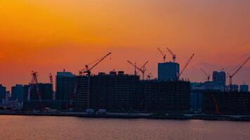 A time lapse of moving cranes at the bay area in Tokyo at dusk wide shot video