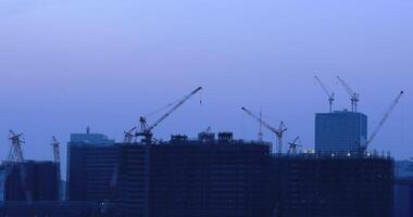 Cranes on the building at the under construction in Ariake Tokyo at dusk video