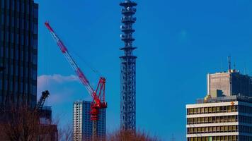 un lapso de tiempo de grúas a el debajo construcción detrás el azul cielo en tokio video