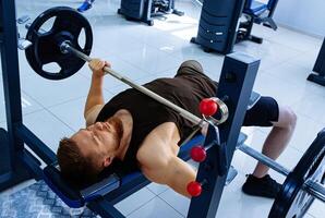 Muscular training man in gym. Sport lifestyle workout. photo