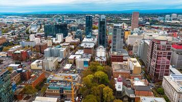 Downtown of Portland, Oregon, the USA with high-rise architecture. Twilight view of the city with mountain silhouettes at backdrop. photo