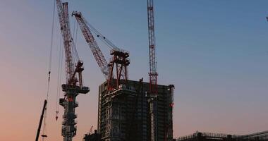 Cranes at the under construction in Tokyo wide shot at dusk video