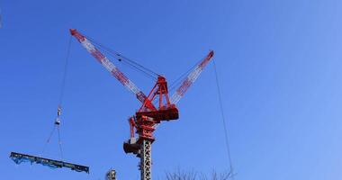 Moviente grúas a el debajo construcción detrás el azul cielo en tokio video