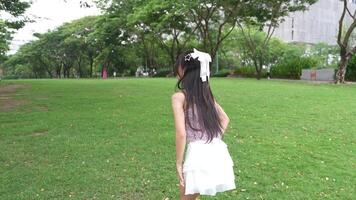 Asian girl dancing and cheering, moving her arms Inside the park during the day video