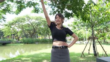 Asian girl dancing and cheering, moving her arms Inside the park during the day video