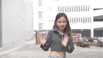 ung asiatisk kvinna gående och dans i de stad. stil. höft hopp och freestyle. video
