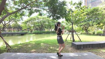 Asian girl dancing and cheering, moving her arms Inside the park during the day video