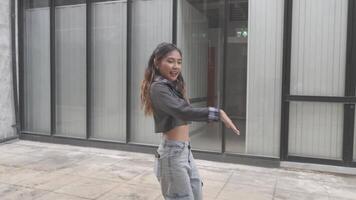 Jeune asiatique femme en marchant et dansant dans le ville. style. hanche saut et style libre. video