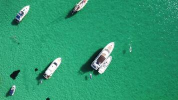 Aerial panoramic view of seascape with crystal clear azure sea and rocky shores. Yachts in a beautiful lagoon on backdrop of rocks. The concept of an ideal destination for summer travel and vacation. video