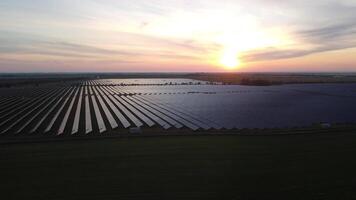 Aerial top view of a solar panels power plant. Photovoltaic solar panels at sunrise and sunset in countryside from above. Modern technology, climate care, earth saving, renewable energy concept. video